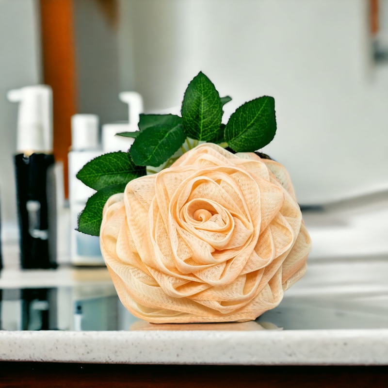 A pink rose loofah sitting on top of a counter in a bathroom