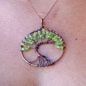 A woman wearing an Olive Quartz Tree of Life pendant necklace.