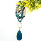 A Multi Stone 108 Mala Gemstone Bead Necklace with Pendant-Clear Quartz featuring a turquoise and white stone.