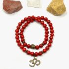 A Red Howlite Gemstone Bead Double Om Charm Bracelet featuring an om symbol.