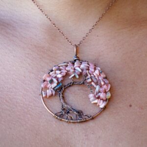 A woman is wearing a Rhodochrosite Tree of Life Pendant.