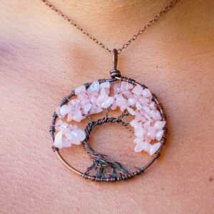 A woman adorns a Rose Quartz Tree of Life Pendant.