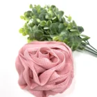 A pink rose loofah on a white background with eucalyptus flowers.