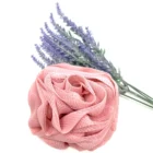 A pink rose loofah on a white background with lavender flowers.