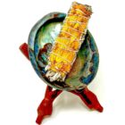 A 4" California White Sage Smudge with Sun Flower Petals adorned with sunflower petals, rested gracefully in a bowl on a stand.