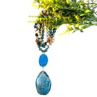 A Multi Stone 108 Mala Gemstone Bead Necklace with Pendant with a blue stone and a flower, making it a perfect gift for women. This beautiful necklace also serves as a healing accessory.