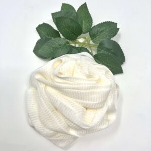 A Rose Loofah- White towel with a green leaf on it, resembling a loofah.