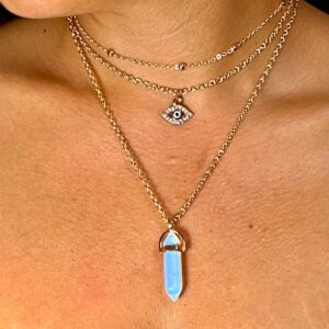 A woman wearing a White Clear Quartz Natural Stone Necklace with an opal stone on it.