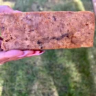 A person holding a bar of African Black Soap in their hand.