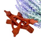 A wooden star shaped object next to a purple flower on a 4" Wooden Tripod Stand.