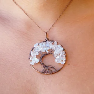 A woman is wearing an Opal Tree of Life Pendant.