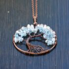 An Aquamarine Tree of Life pendant featuring blue topaz and copper wire.