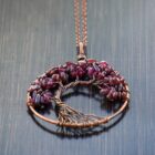 A Garnet Tree of Life Pendant with a tree of life on it.