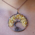 A woman is wearing a Citrine Tree of Life Pendant.