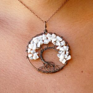 A woman is wearing a Howlite Tree of Life Pendant.