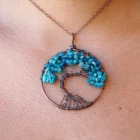 A woman is wearing an Apatite Tree of Life Pendant necklace.