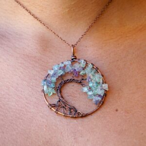 A woman is wearing a Flourite Tree of Life Pendant necklace.