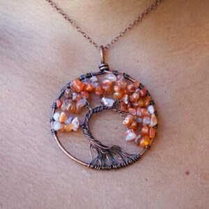 A woman is wearing a Carnelian Tree of Life Pendant.