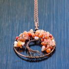 A copper Carnelian Tree of Life pendant necklace adorned with vibrant orange Carnelian stones.