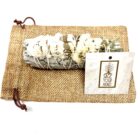 4" California White Sage Smudge Sticks with White Sinuata Flowers in a sack with a tag, perfect for smudging and purification rituals.