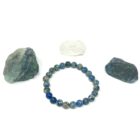 A Royal Blue Sea Sediment Gemstone Bracelet adorned with sea sediment stones, along with a rock.