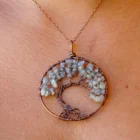 A woman is wearing a Labradorite Tree of Life Pendant.