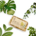 An African Black Soap bar adorned with green leaves.