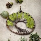 An Olive Quartz Tree of Life pendant adorned with vibrant green peridots.