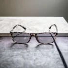 A pair of Blue Light Blocking Photochromic Glasses Rectangle Lenses - Leopard sitting on top of a table.