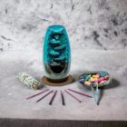 A Turquoise Ceramic Waterfall Backflow Incense Burner with Mixed Incense Cones, Sticks & Sage with mixed incense cones and a waterfall backflow.