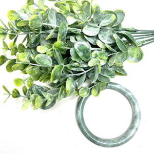 Green eucalyptus leaves and a green Jade Bangle Bracelet.